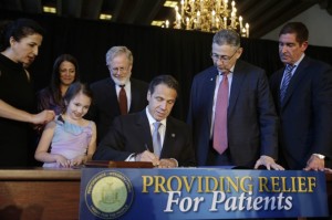 New York Governor Andrew Cuomo (C) signs a ceremonial bill to establish a medical marijuana program(AP Photo-Seth Wenig)